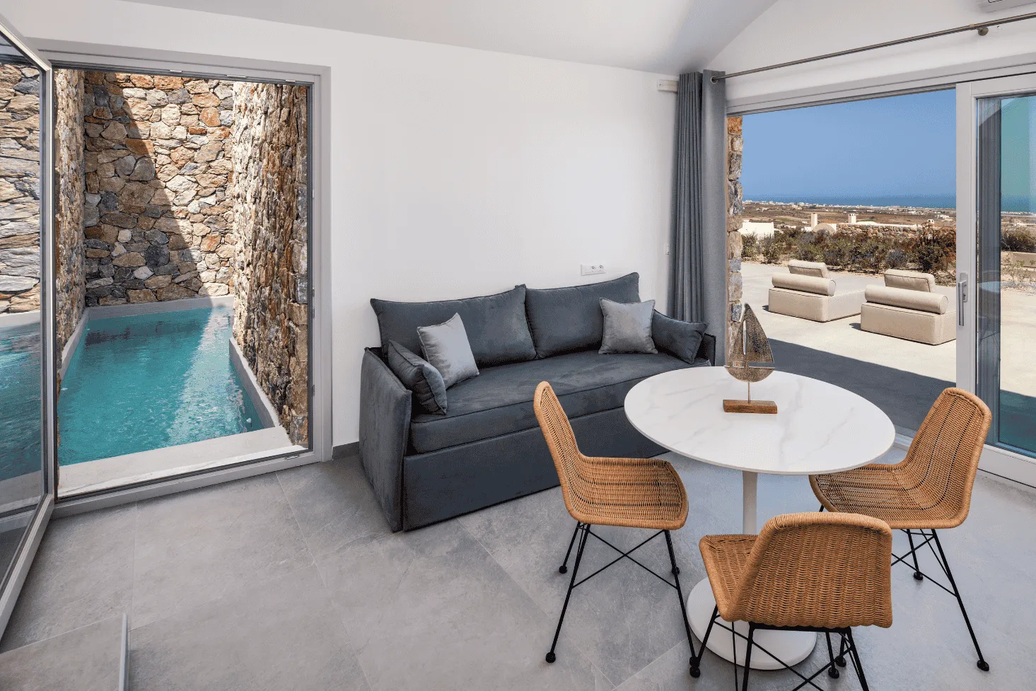 Deluxe Eros Cave Villa spacious living area - Stone interior with pool access and panoramic sea views